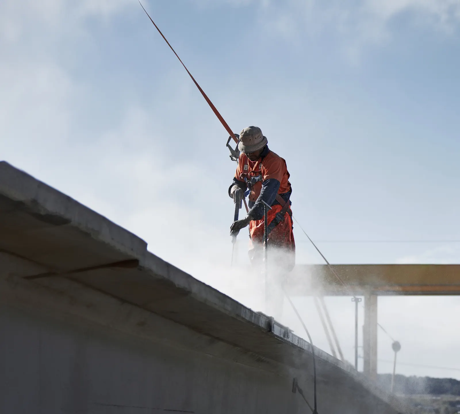 A worker hosing down a deck on site