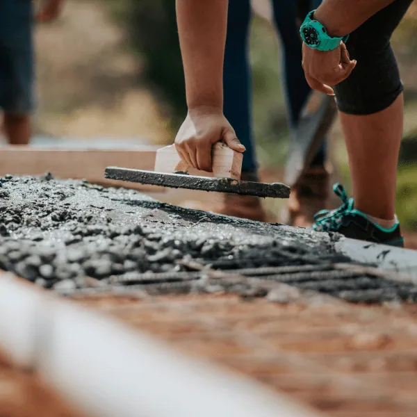 Construction workers levelling fresh cement on site