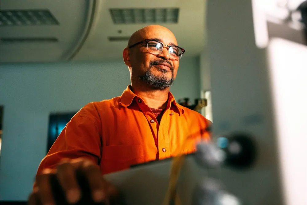 A worker in orange hi-vis at a machine