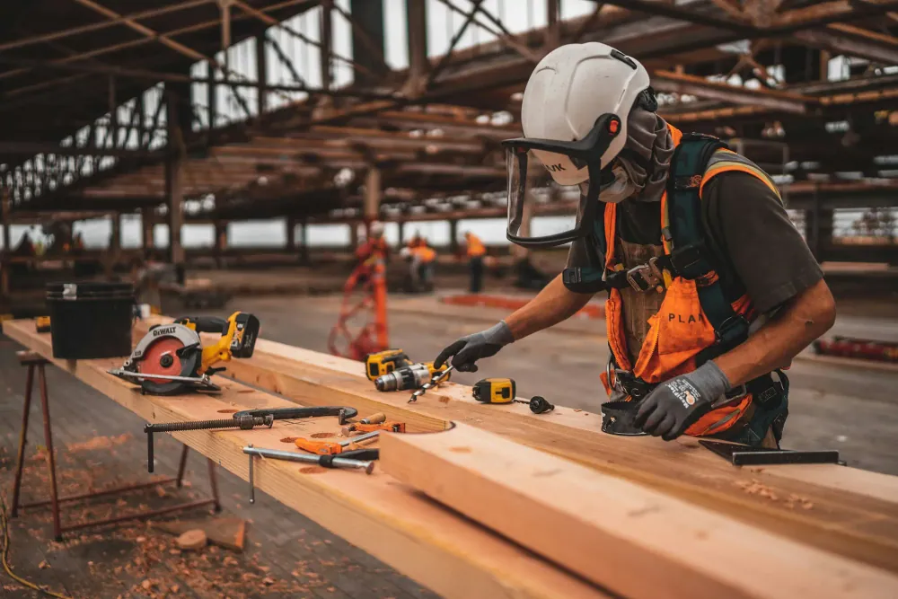 A worker using power tools on a construction site
