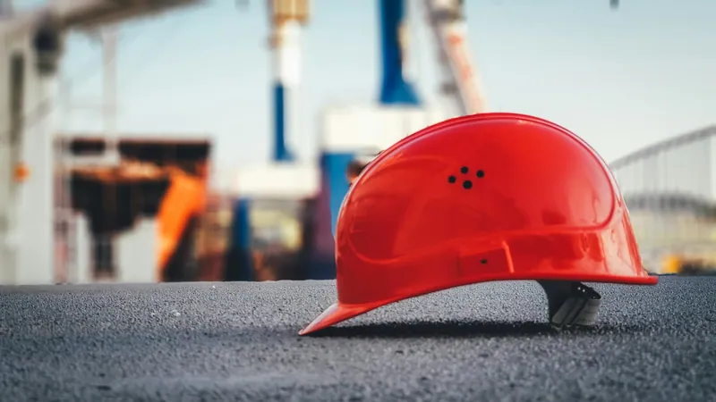A red hard hat on the ground at a work site